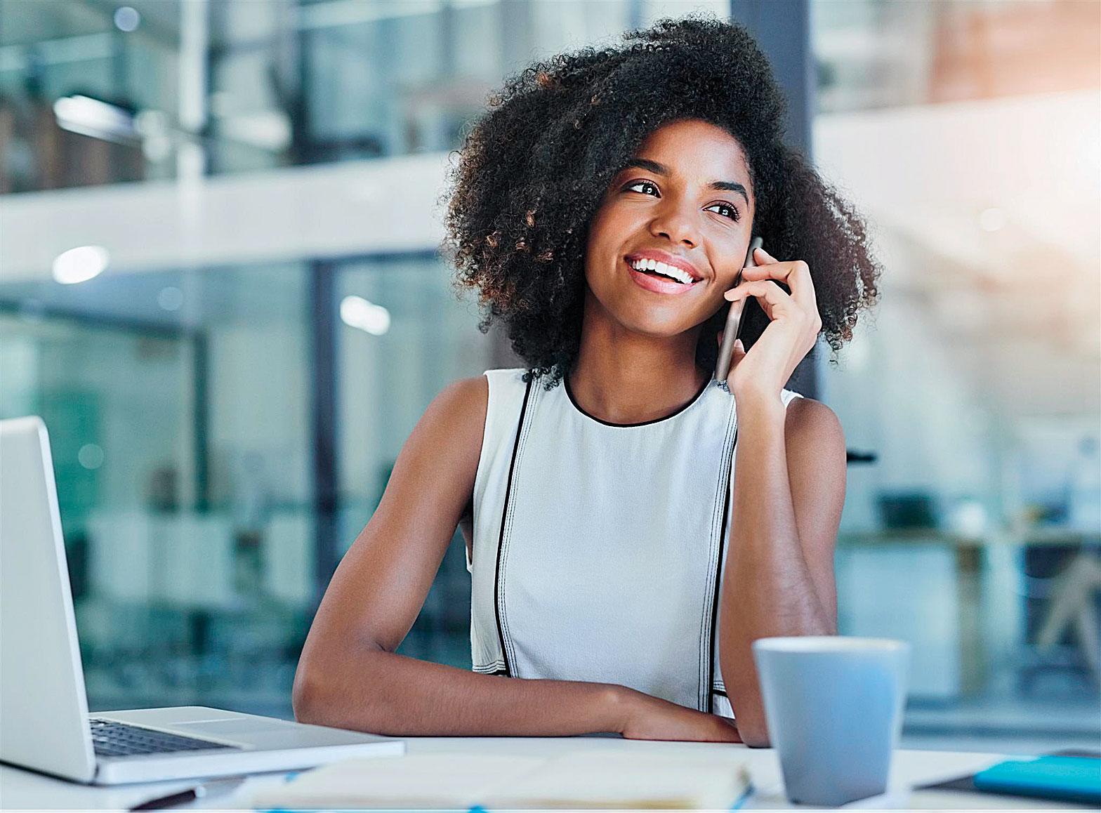 Happy-Black-Woman-at-desk-on-phone